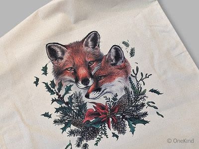 A white tea towel with a festive illustration of foxes and holly on it