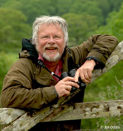 TV presenter Bill Oddie leaning on a fence